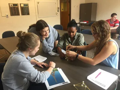 Volunteers building a spaghetti-marshmallow tower